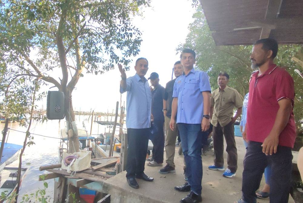 Muhammad Faiz (tengah) ketika melawat jeti nelayan di Kuala Sedaka, Yan pada Sabtu.