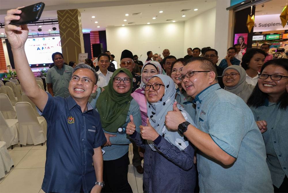 Fahmi berswafoto dengan orang ramai selepas merasmikan program Jiwa Kita Madani di pasaraya Mydin, pada Sabtu. - Foto Bernama