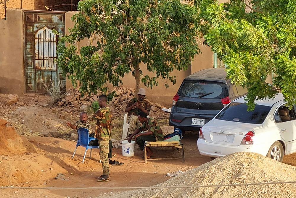 Anggota pasukan keselamatan Sudan yang bergabung dengan tentera berehat di bawah pokok di Khartoum pada Sabtu. - Foto AFP