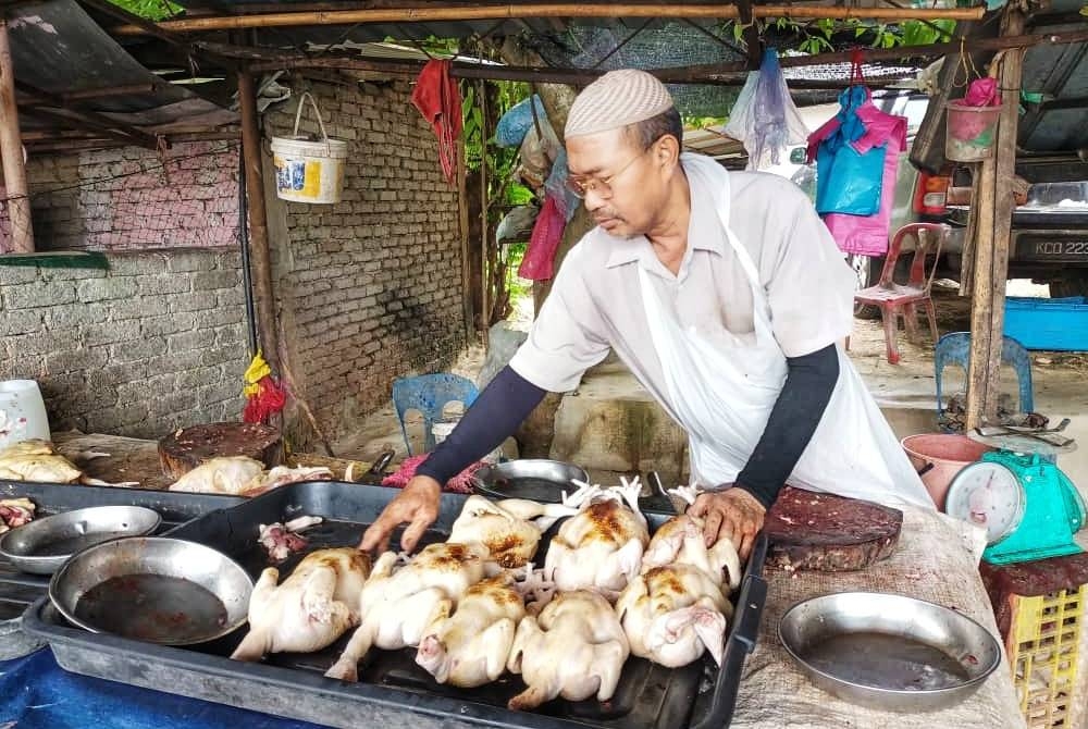 Yusof sedang menyusun ayam jualannya di gerainya di Ladang Rakyat, Bukit Kayu Hitam, Kedah pada Ahad.