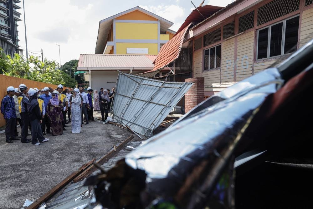 Alexander Nanta Linggi bersama Fadhlina ketika hadir hari ini meninjau kerosakan yang dialami Sekolah Kebangsaan Setapak, Kuala Lumpur kesan daripada dilanda ribut pada 19 Mei lalu. - Foto Bernama