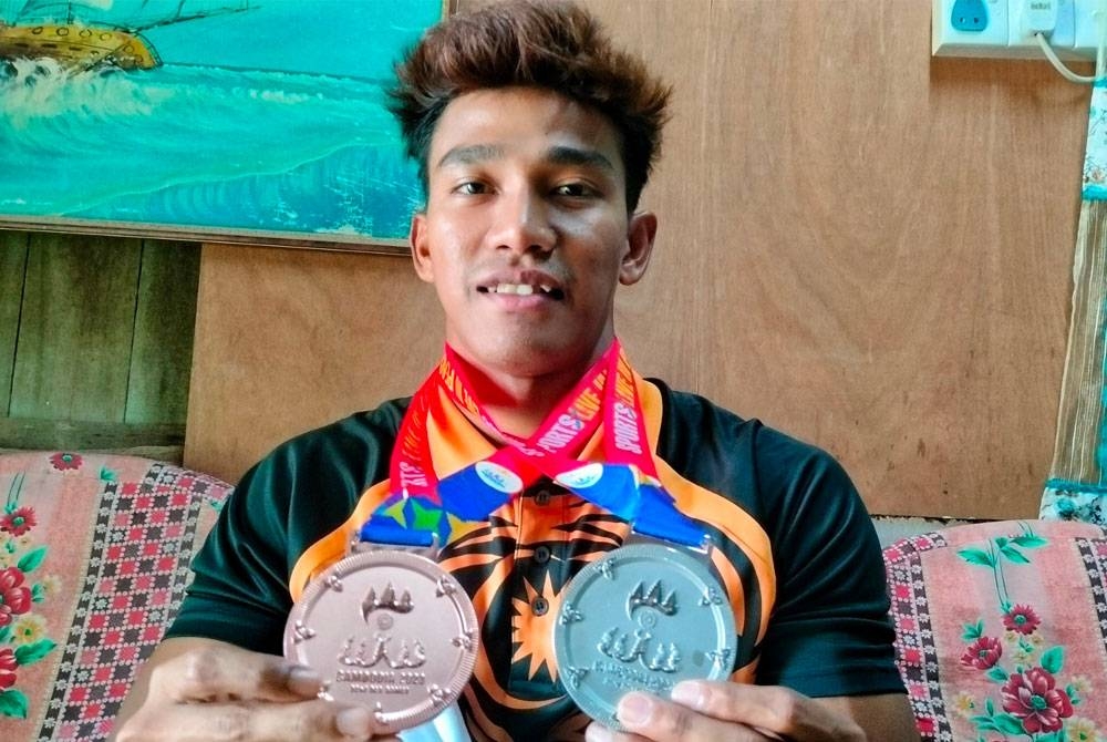 Ahmad Nuqman menunjukkan pingat perak dan gangsa yang dimenangi dalam Kejohanan Sukan Asia Tenggara (SEA) yang berlangsung di bandar Kampot, Kemboja baru-baru ini.