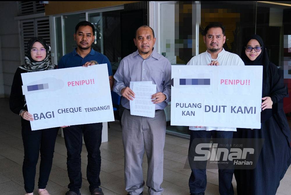 Rusman bersama beberapa peserta memegang plakad menuntut sebuah syarikat pengendali umrah membuat pembayaran balik kepada mangsa. - Foto Sinar Harian/MOHD HALIM ABDUL WAHID