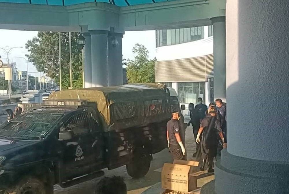 Anggota polis mengangkat mayat yang ditemui di bawah ruang parkir kenderaan sebuah hotel.