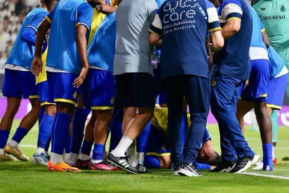 Ronaldo bersujud selepas meledak gol kemenangan Al Nassr sambil dikelilingi rakan sepasukan.