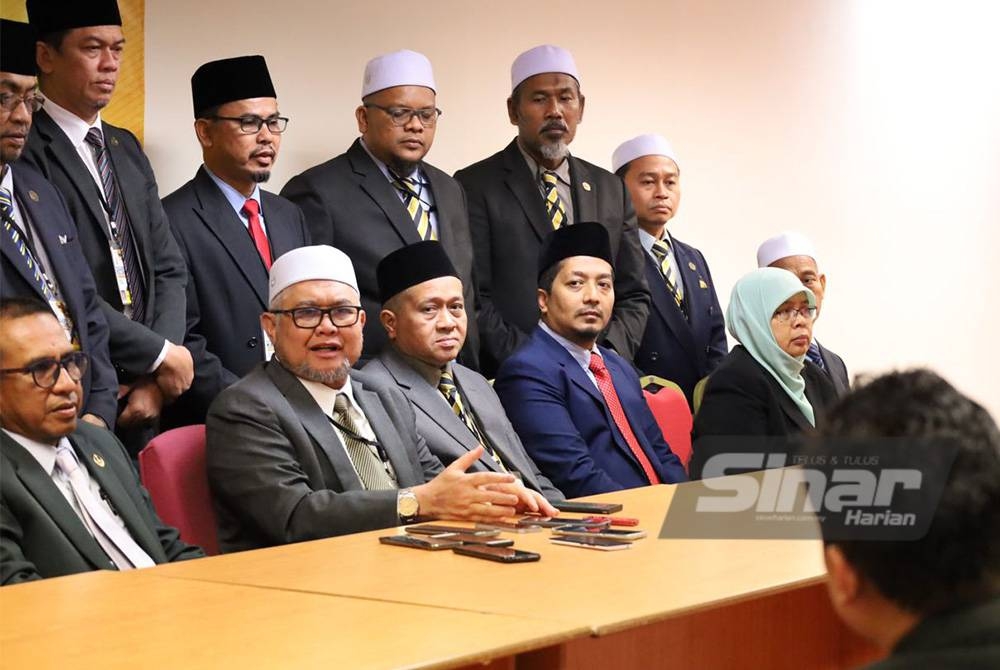 Razman (duduk, dua dari kiri) dan Zainol Fadzi (duduk, kiri) bersama semua ADUN pembangkang ketika sidang akhbar di Bilik Sidang Media DUN Perak pada Rabu.