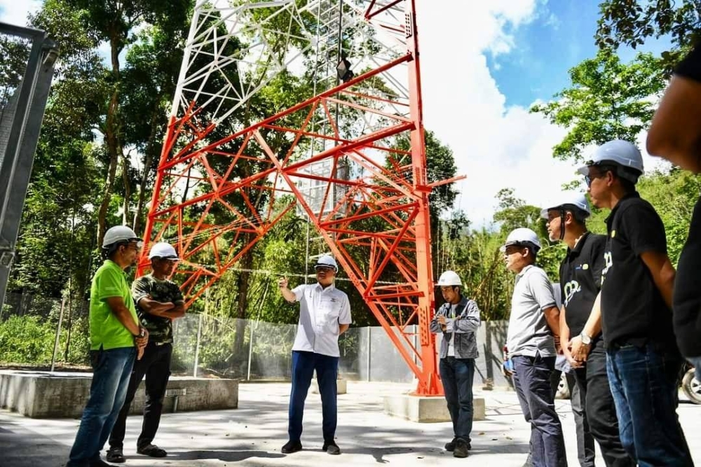 Fadzli (tengah) meninjau menara telekomunikasi yang bakal memberikan kemudahan buat lebih 600 penduduk Kampung Orang Asli Kuala Boh,Cameron Highlands.