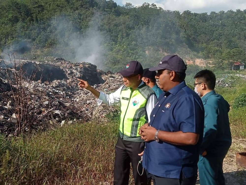 Raven Kumar (kanan) dan Dr Mohd Famey meninjau tapak pembuangan sampah haram di Ulu Choh.