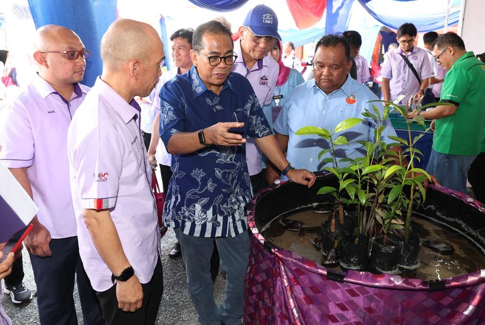 Mohamed Khaled melihat pameran teknologi penternakan ketam nipah pada Program Semarak Komuniti Kota Tinggi di Sekolah Kebangsaan Sedili Besar, Kota Tinggi pada Ahad. - Foto Bernama