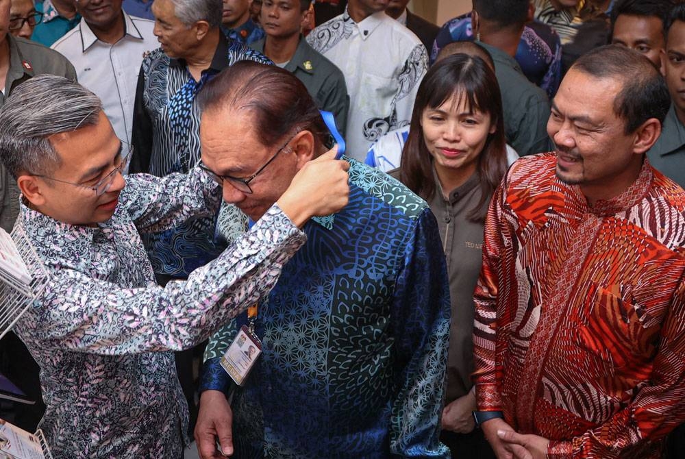 Anwar menerima kalungan Pas Akreditasi Media daripada Fahmi (kiri) pada kemuncak sambutan Hari Wartawan Nasional (Hawana) 2023 di Hotel Casuarina, Meru pada Ahad. - Foto Bernama