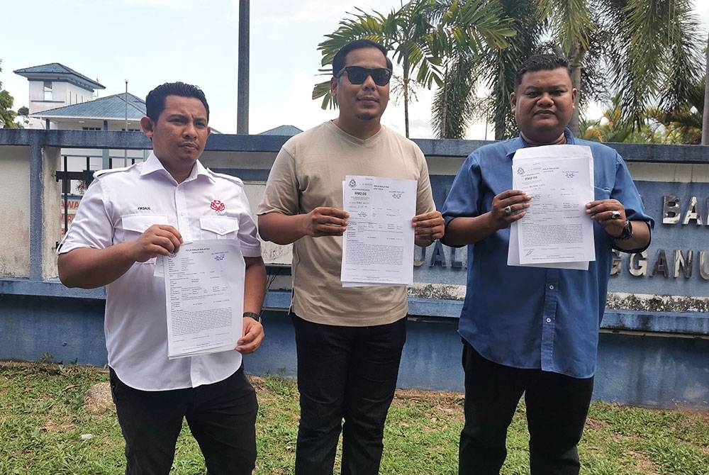 Mohd Hafiz (tengah) bersama Muhammad Firdaus Ruslan (kiri) dan Norrimusrizal Muslim selepas membuat laporan di Balai Polis Gong Badak, di Kuala Nerus pada Isnin.