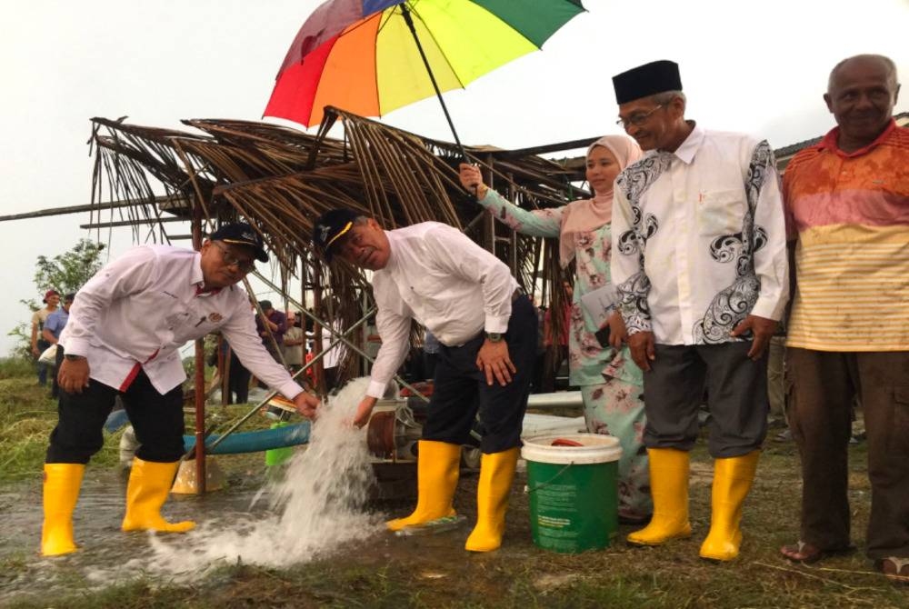 Mohamad (dua dari kiri) melihat telaga tiup yang digali di Kubang Telaga, Bachok.