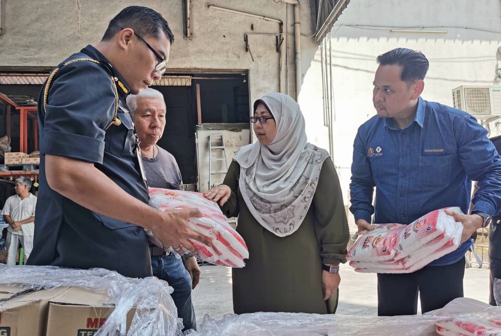 Fuziah (dua dari kanan) bersama Saharuddin (kanan) ketika melakukan lawatan kerja di sebuah syarikat pemborong, pada Selasa.