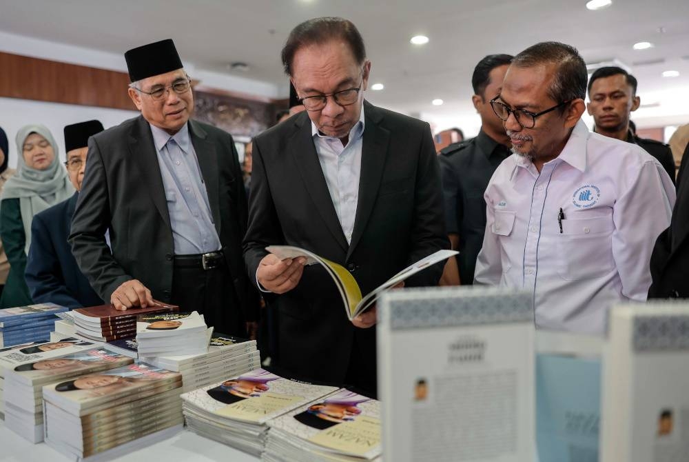 Anwar melihat buku sewaktu melawat tapak pameran pada Majlis Perasmian Seminar Fikrah Siddiq Fadzil 'Citra Budaya dan Peradaban Bangsa Malaysia' di Balai Budaya Tun Syed Nasir, Wisma Dewan Bahasa dan Pustaka pada Selasa. - Foto Bernama