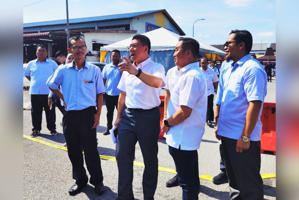 Kor Ming (depan dua dari kiri) meninjau gerai penjaja di Pasar Awam Sekinchan pada Rabu.