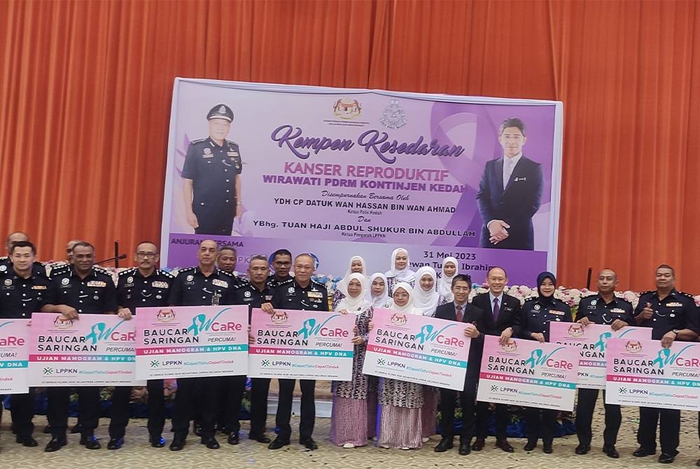 Wan Hassan (tengah) memegang replika baucar saringan bersama barisan ketua-ketua jabatan dan ketua polis daerah selepas Kempen Kesedaran Kanser Produktif Wirawati PDRM Kontinjen Kedah di IPK Kedah pada Rabu.