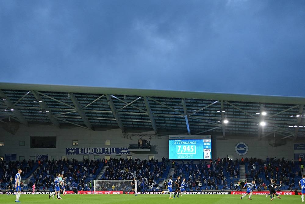 Skrin memaparkan penonton yang hadir semasa perlawanan Liga Perdana Inggeris, Brighton & Hove Albion menentang Manchester City di Stadium Komuniti American Express di Brighton, selatan England pada 18 Mei 2021. Saingan EPL antara perlawanan bola sepak yang mempunyai peminat di seluruh dunia. FOTO: AFP