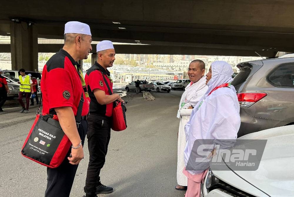 Wan Shamsol (kiri) bersama anggotanya menyantuni jemaah haji berhampiran Hotel Abraz Janadriyah.