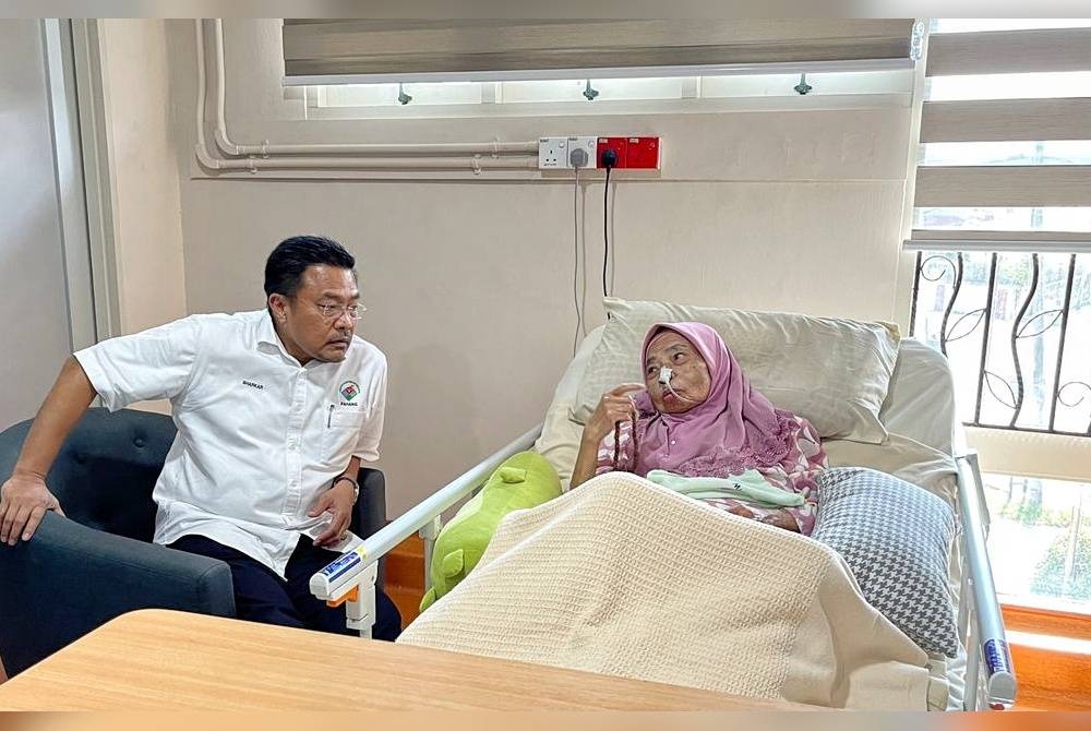 Sharkar (kiri) ketika melawat Rahimah pada program ziarah kasih di Dailycare KPJ Teluk Sisek di sini.