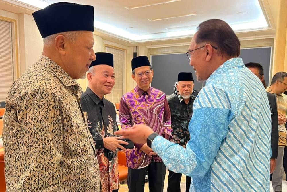 Ahmad (kiri) Azami (dua, kiri) bersama Anwar pada mesyuarat yang diadakan di Putrajaya pada Khamis.