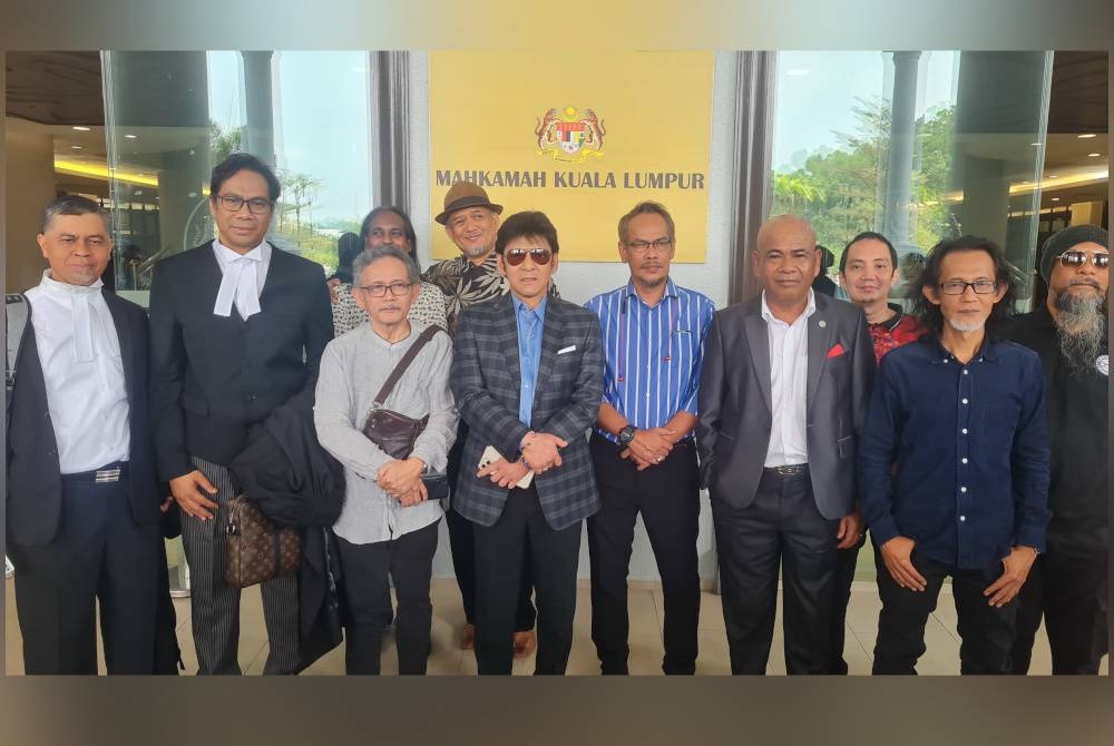 Jamal (empat, kiri), Aris (lima, kiri) bersama sebahagian daripada rakan artis, hadir di Mahkamah Tinggi Kuala Lumpur pada Khamis, bagi prosiding kes mereka terhadap PRISM.