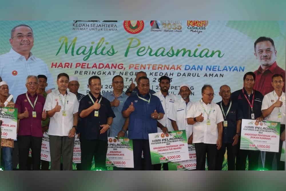 Muhammad Sanusi (tengah) bergambar bersama 16 penerima pelbagai anugerah sempena Hari Peladang, Penternak dan Nelayan peringkat negeri Kedah di pekarangan Stadium Darul Aman.