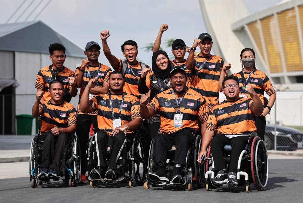 Ketua Kontinjen (CDM) Malaysia ke APG Kemboja 2023 Noor Syahieda Mat Shah (belakang, tengah) bersama Atlet paralimpik olahraga yang akan menggalas cabaran negara di temasya Sukan Para ASEAN (APG) ke-12 di Kemboja bersemangat waja melaungkan slogan &#039;Demi Malaysia’ di Stadium Nasional Morodok Techo petang ini. - Foto Bernama