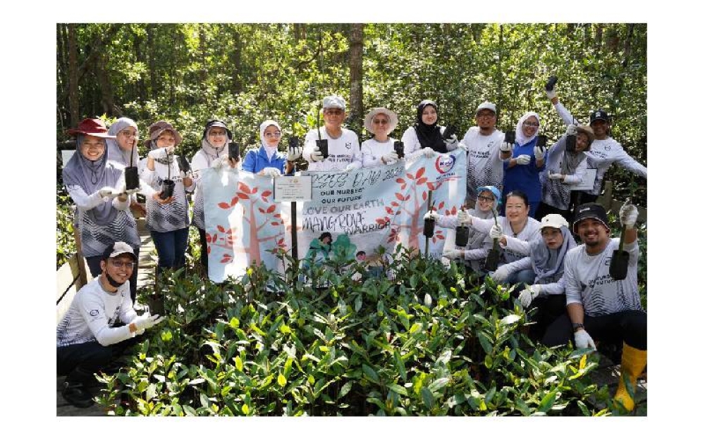 Azhar (berdiri, tengah) bersama jururawat Hospital Pakar KPJ Puteri menyemai 52 benih pokok bakau. 