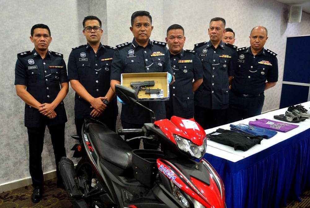 Noor Dellhan (tengah) menunjukkan pistol tiruan yang digunakan suspek bagi menakutkan mangsa dalam satu kejadian kes rompakan di Kampung Baru, Kuala Lumpur pada 31 Mei lalu. Foto Sinar /Asril Aswandi Shukor.