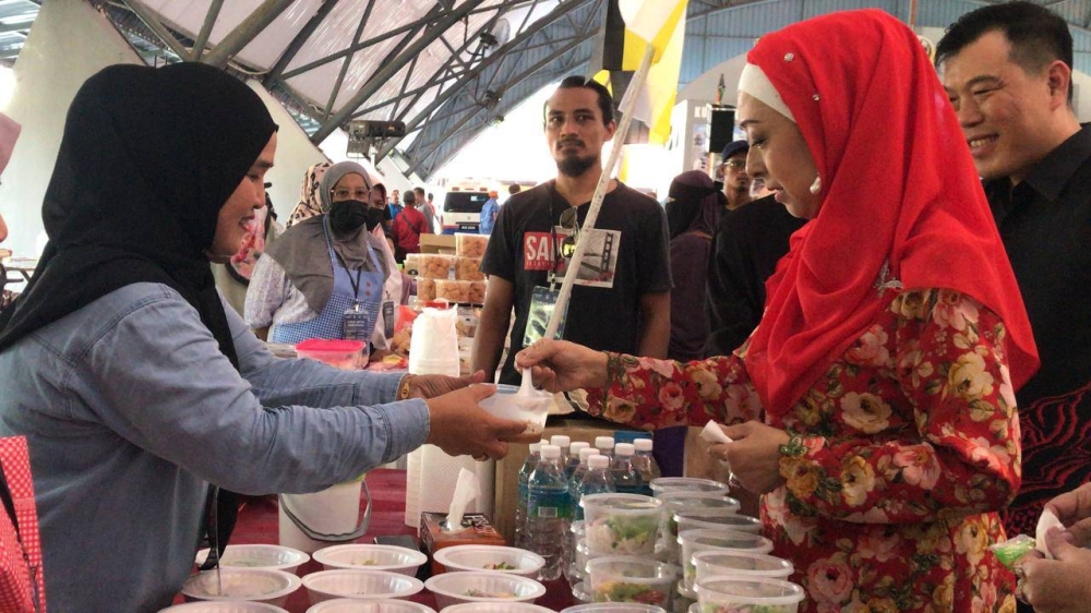 Raja Nazhatul Shima merasai kuah laksa yang disediakan pengusaha pada Pesta Laksa Kuale. 