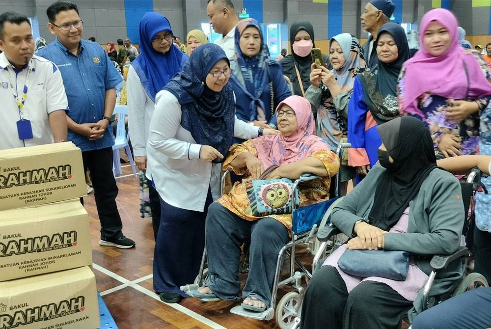 Fuziah beramah mesra bersama sebahagian asnaf penerima sumbangan Rahmah pada majlis penyerahan sumbangan itu di Dewan Datuk Seri Abdul Manan Ismail pada Sabtu.