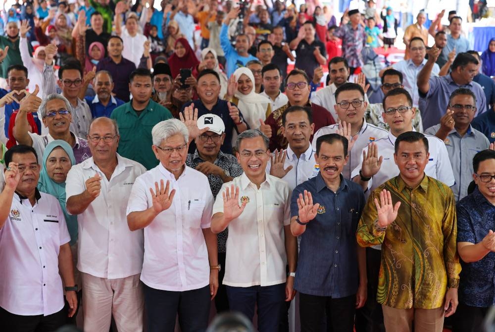 Fahmi (tengah) bergambar bersama Mohamad Fauzi (tiga dari kanan) dan Ahmad Zakiyuddin (tiga dari kiri) serta orang ramai yang hadir pada Majlis Prapelancaran Komuniti Madani hari ini. - Foto Bernama