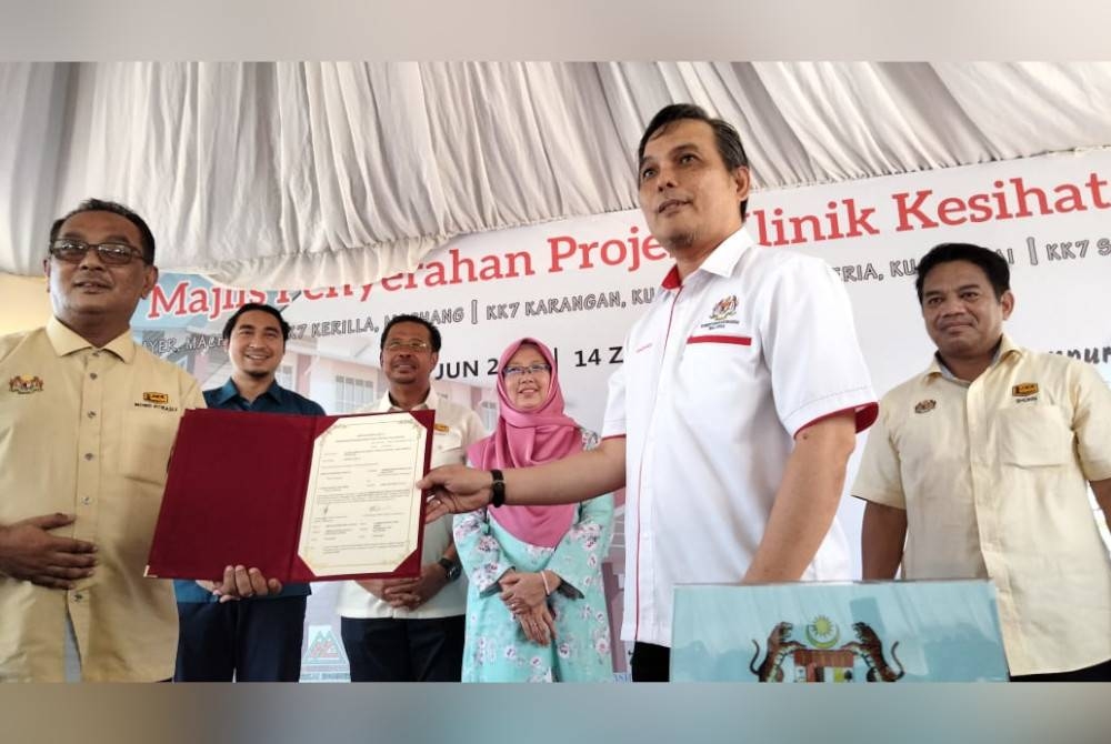 Dr Zaliha (dua dari kanan) menyaksikan penyerahan dokumen daripada Ir Suhaili kepada Mohd Rashidi (kanan) pada majlis penyerahan Projek Klinik Kesihatan Jenis 7 di Klinik Kesihatan Mata Ayer pada Sabtu.