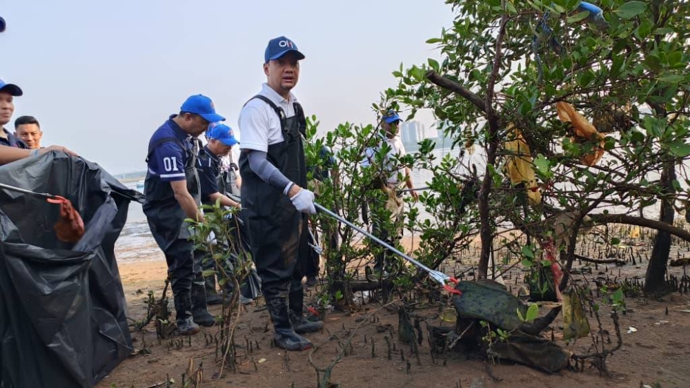 Onn Hafiz mengutip sampah di pesisiran Sungai Skudai pada Program Johor Bersih @ Sungai Skudai di Kampung Bakar Batu pada Ahad.