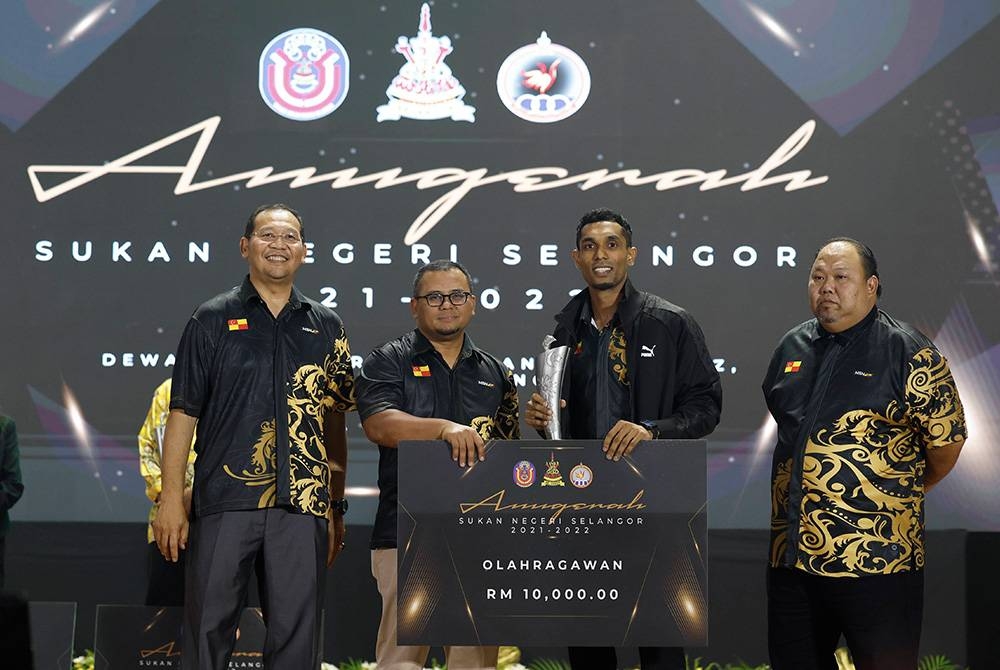 Amirudin (dua dari kiri) menyampaikan Anugerah Olahragawan kepada atlet Karate R Sharmendran pada Majlis Anugerah Sukan Negeri Selangor 2021-2022 di Dewan Jubli Perak Sultan Abdul Aziz pada Ahad. - Foto Bernama