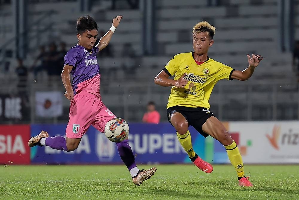 Zahrul (kiri) ketika melakukan percubaan sambil dihalang pemain Negeri Sembilan, Filemon Anyie dalam aksi Liga Super di Stadium Negeri, Petra Jaya pada Ahad.