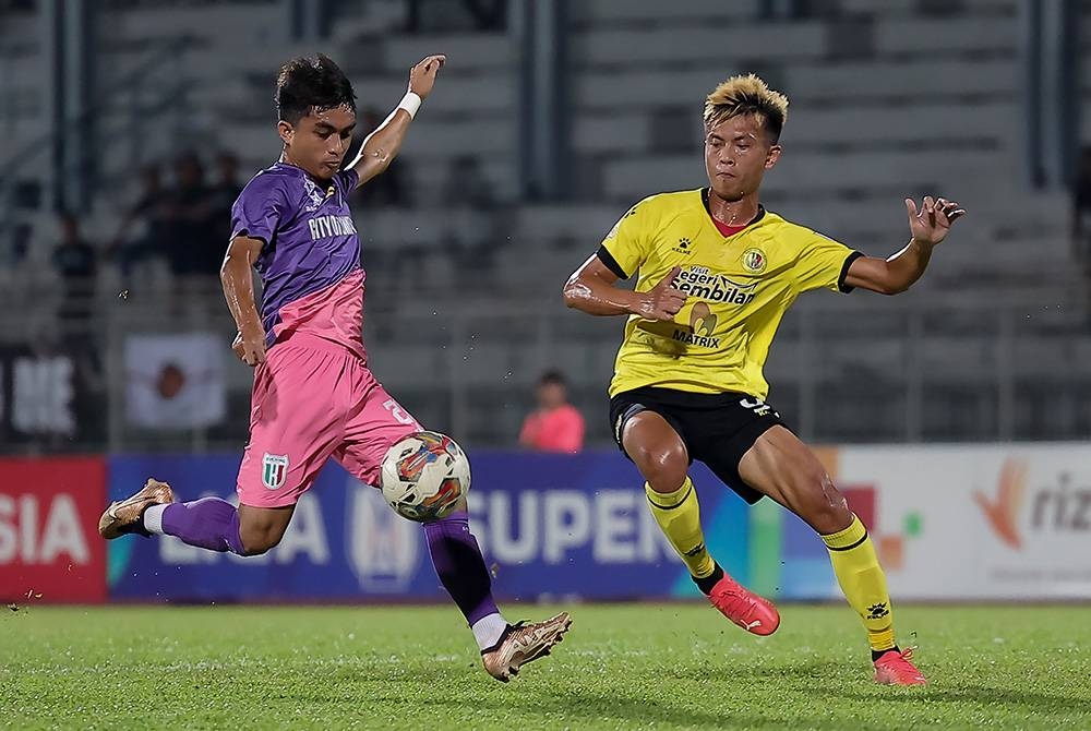 Pemain Negeri Sembilan, Filemon Anyie menghalang percubaan Zahrul (kiri) semasa aksi Liga Super di Stadium Negeri, Kuching pada Ahad.