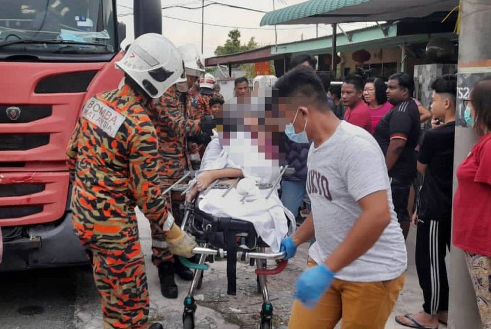 Pasukan bomba mengusung kanak-kanak yang tertusuk besi pagar untuk dibawa ambulans ke HTAJ Sabak Bernam pada Isnin.