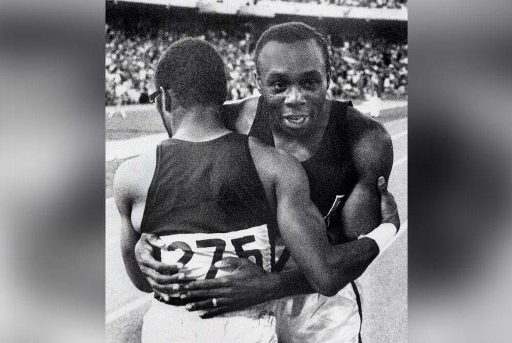 Hines (kanan) menerima ucapan tahniah daripada rakan senegaranya Charles Green atas kemenangan acara 100m Sukan Olimpik Mexico 1968, mencatat masa 9.9 pada 14 Oktober 1968 di Mexico City. - FOTO AFP