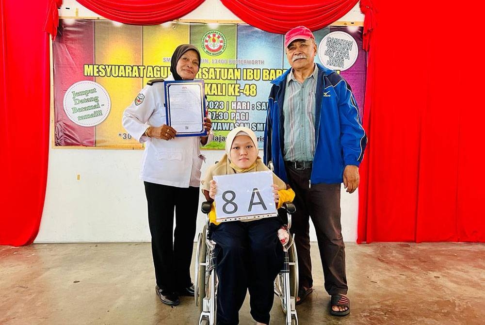 Nur Farrisha bersama ibu dan bapanya selepas mengambil keputusan SPM 2022 di SMK Mak Mandin pada Khamis.