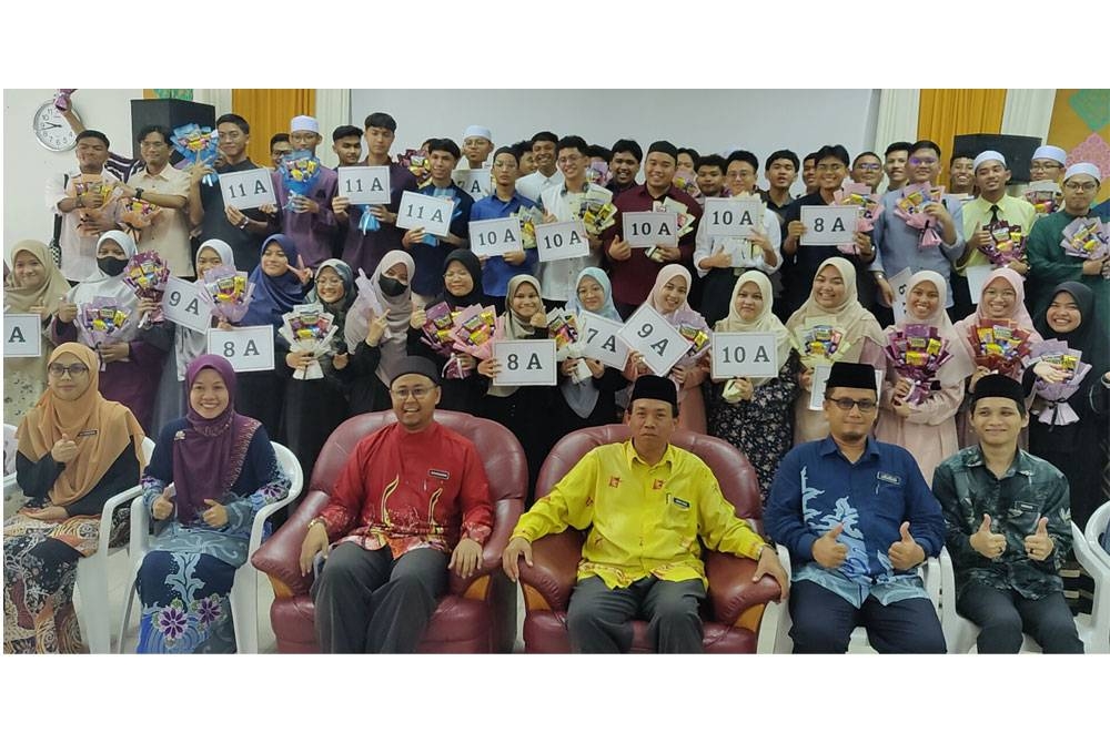 Mohd Shari (duduk depan tiga dari kanan) bergambar bersama calon SPM 2022 selepas Majlis Pengumuman Keputusan SPM MITS Sabak Bernam di sini pada Khamis.