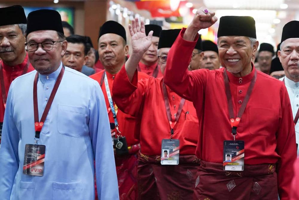 Presiden UMNO, Datuk Seri Dr Ahmad Zahid Hamidi dan Anwar berjalan seiringan ketika menuju ke Dewan Merdeka pada Perhimpunan Agung UMNO 2023 yang diadakan di Pusat Dagangan Dunia Kuala Limpur pada Jumaat.