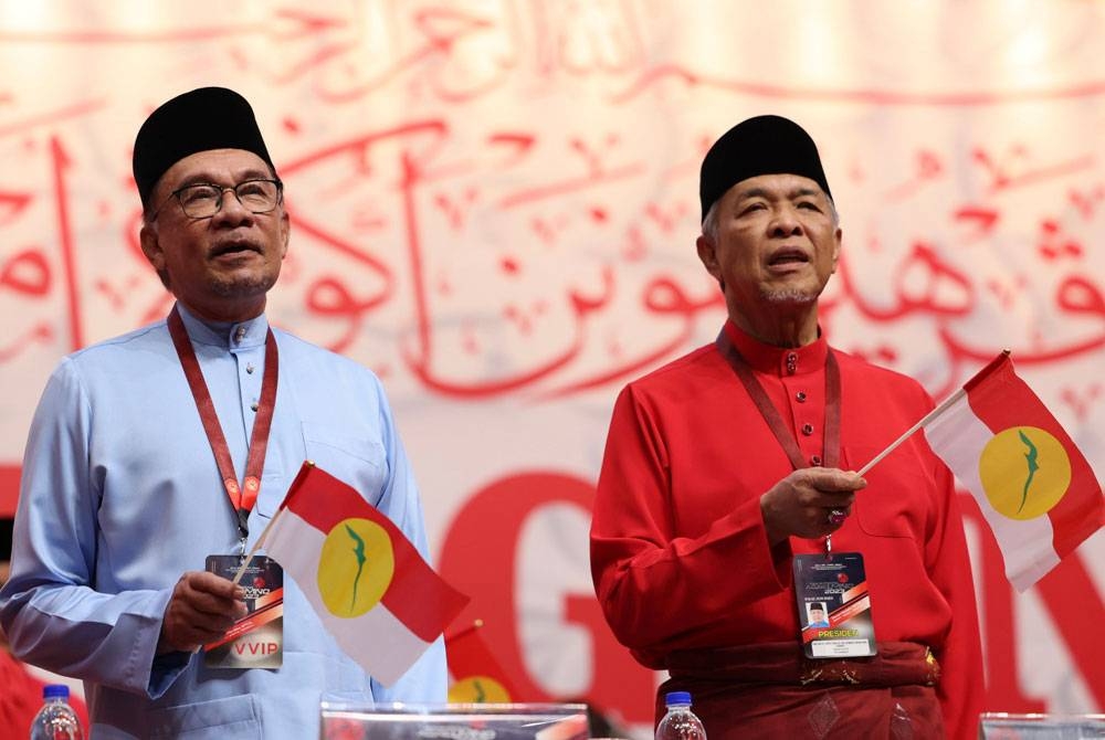 Anwar (kiri) ikut sama menyanyikan lagu UMNO sempena PAU 2023 pada Jumaat.