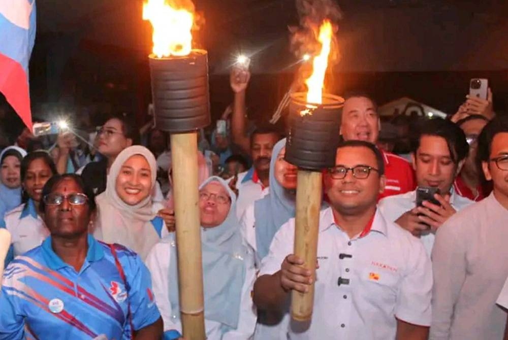 Amirudin (dua dari kanan) bergambar sambil memegang obor selepas Majlis Pelancaran Jentera Pilihan Raya AMK dan Wanita PKR Selangor di Padang Awam Kampung Permatang di sini pada Jumaat malam.