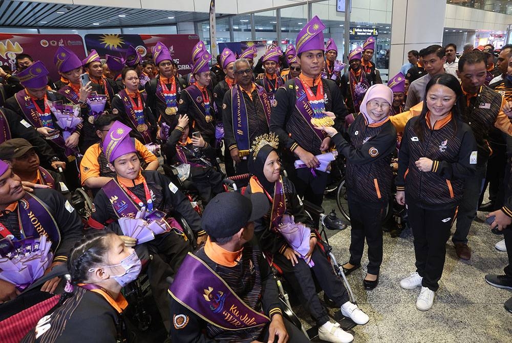 Dr Wan Azizah (dua dari kanan) dan Hannah (kanan) menyantuni para atlet semasa menyambut kepulangan Kontinjen Sukan Para ASEAN ke-12 2023 di KLIA hari ini. - Foto Bernama