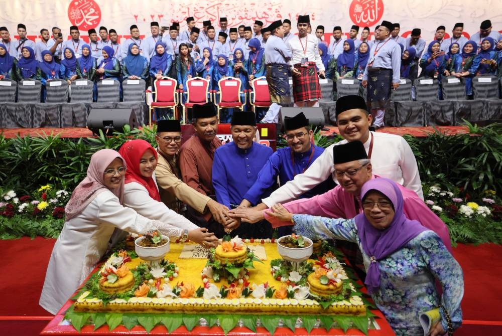 Ahmad Zahid (tengah) memotong pulut kuning selepas selesai menyampaikan ucapan penggulungan pada Perhimpunan Agung UMNO 2023 di WTCKL hari ini. - Foto Bernama