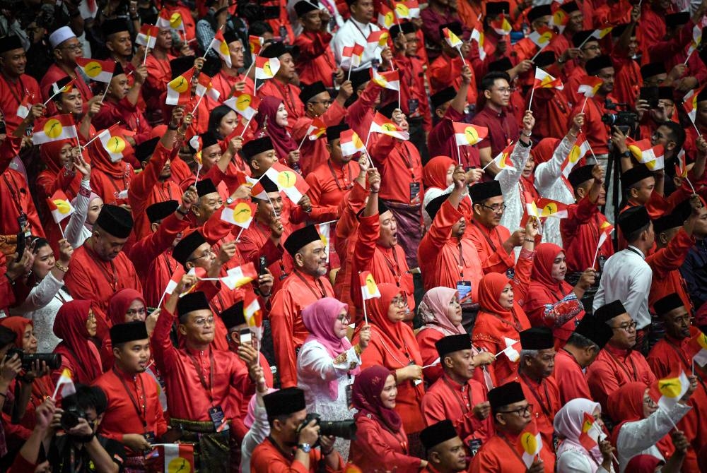 Para perwakilan bersemangat mengibarkan bendera UMNO semasa Perhimpunan Agung UMNO 2023 di Dewan Merdeka, Pusat Dagangan Dunia Kuala Lumpur pada Jumaat.