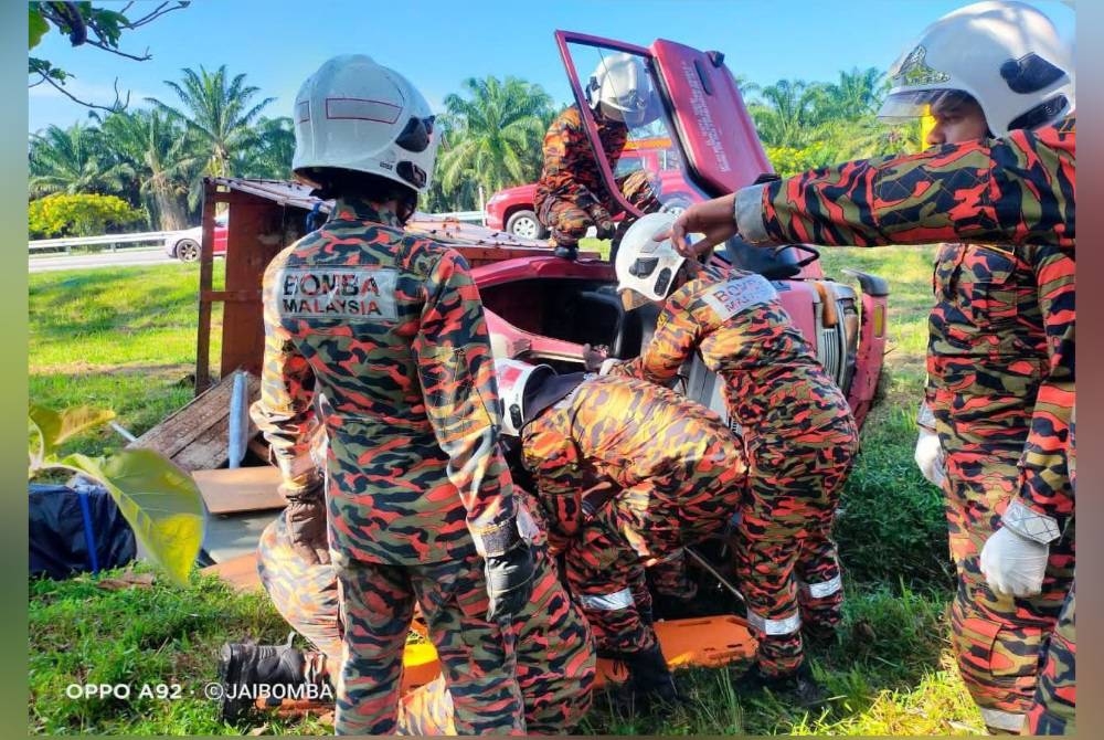 Anggota bomba cuba mengeluarkan mangsa yang tersepit dalam lori satu tan berkenaan. - Foto Bomba Tangkak