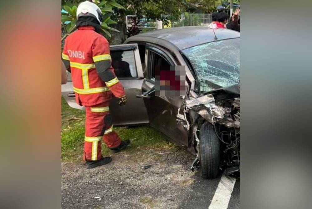 Anggota Bomba dan Penyelamat sedang mengeluarkan pemandu lelaki yang tersepit dalam kemalangan di Jalan Kampung Sungai Lalang, Semenyih pada Isnin.