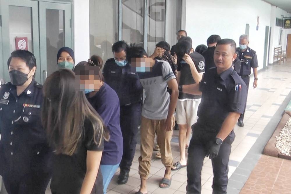 Kesemua tertuduh diiringi polis ketika dibawa keluar dari Mahkamah Majistret di Melaka pada Isnin.